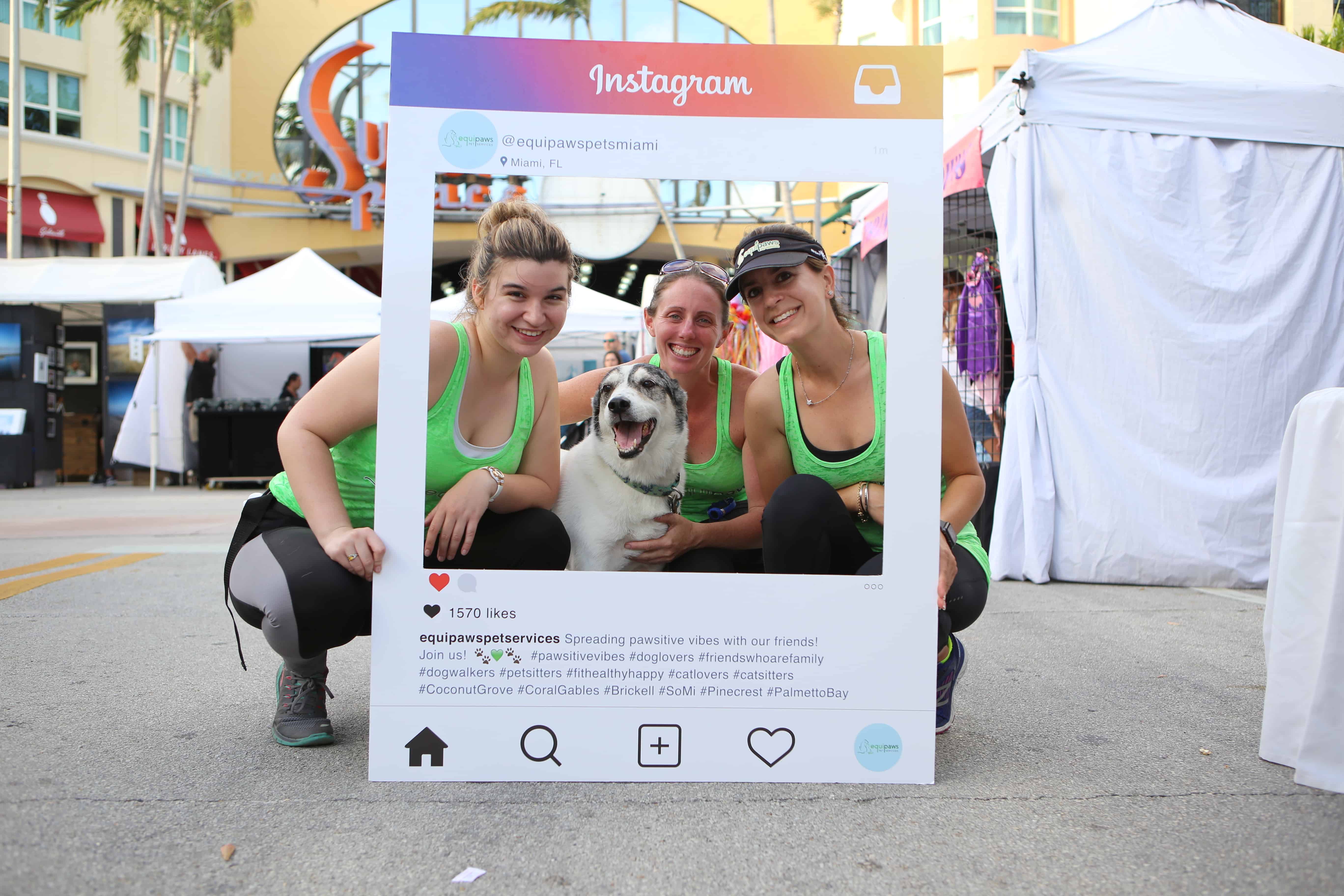 Equipaws team posing with an Instagram frame at the South Miami Rotary Art Festival